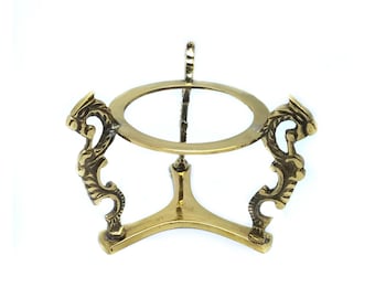 May include: A gold metal orb stand with a round top and three legs. Each leg is decorated with a stylized dragon design.