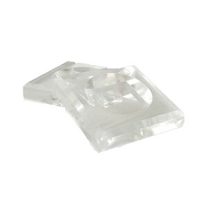 May include: Two clear plastic square-shaped display stands with a circular indentation in the center.