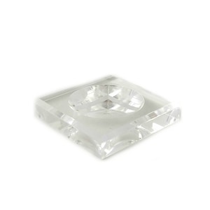 May include: A clear glass square dish with a round indentation in the centre. The dish is made of crystal and has a polished finish.