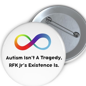 May include: A white button with a rainbow infinity symbol and the text "Autism Isn't A Tragedy. RFK Jr's Existence Is."