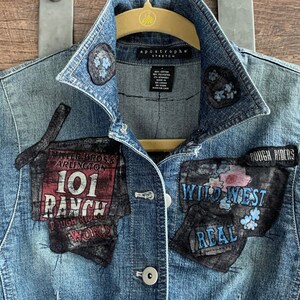 May include: A blue denim jacket with various patches sewn on. The patches include "Miller Bros. & Arlington 101 Ranch", "Rough Riders", "Wild West", and "Real".