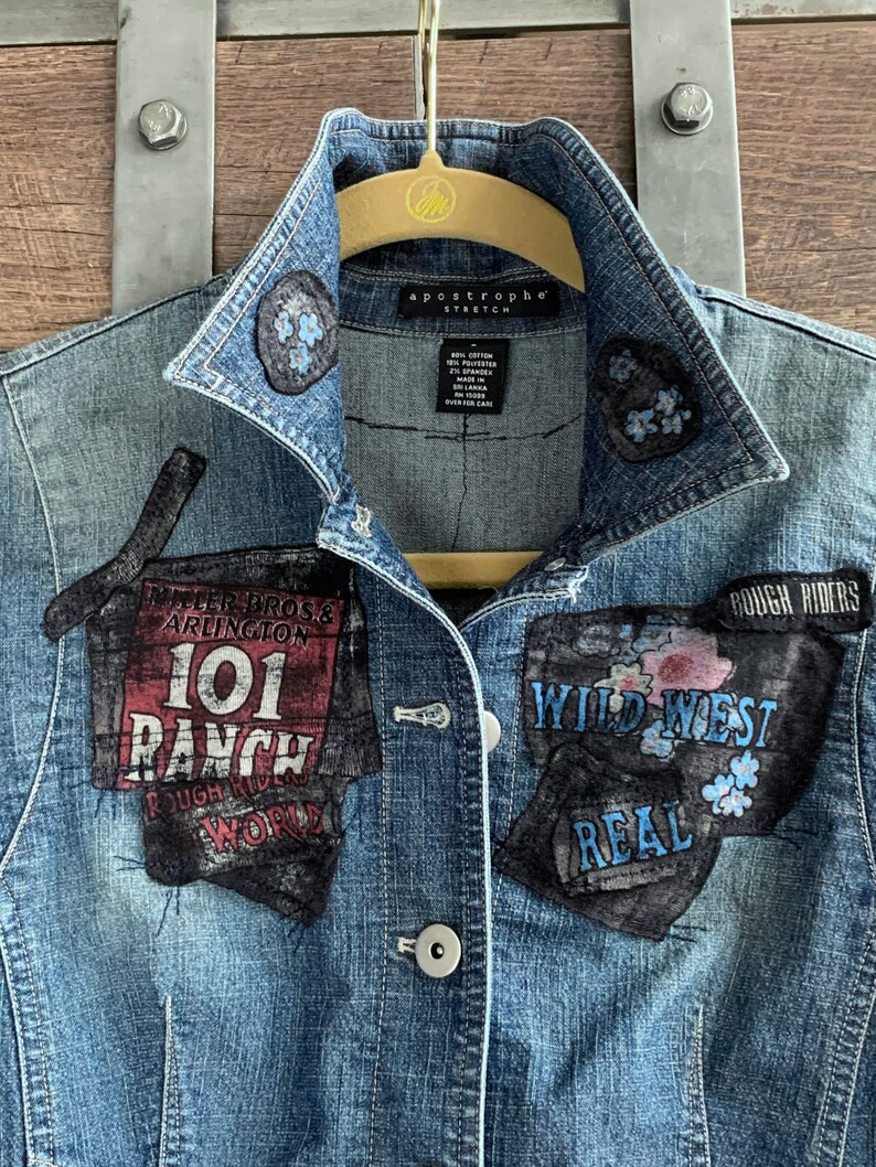 May include: A blue denim jacket with various patches sewn on. The patches include "Miller Bros. & Arlington 101 Ranch", "Rough Riders", "Wild West", and "Real".
