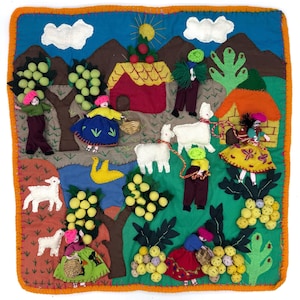 Puede incluir: Una colorida pieza de arte textil hecha a mano que representa una escena rural. La obra de arte presenta figuras, casas, árboles con uvas y animales como ovejas y llamas. El fondo incluye montañas, un cielo azul y nubes. Con un borde naranja.