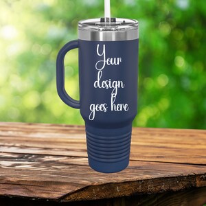 Puede incluir: Un termo de viaje de acero inoxidable azul marino con asa y pajita. El termo tiene una inscripci&oacute;n blanca que dice "Your design goes here".