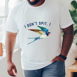 Puede incluir: Camiseta blanca con un gr&aacute;fico de golondrina azul y el texto "I DON'T SPIT. I"