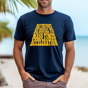 Puede incluir: Una camiseta azul marino con un gráfico amarillo que dice "Que la fuerza sea igual a la masa por la aceleración."