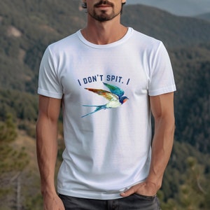 Puede incluir: Camiseta blanca con un gr&aacute;fico de golondrina azul y verde y el texto "I DON'T SPIT. I"