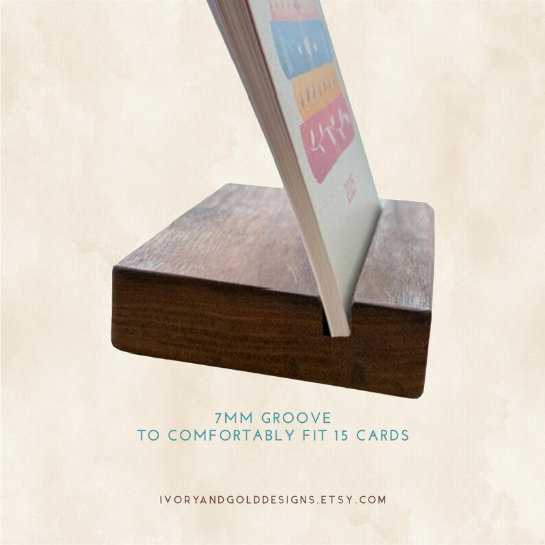 May include: A dark brown wooden card holder with a 7mm groove designed to comfortably fit 15 cards. The holder supports a card with colorful illustrations. The Etsy shop name is visible at the bottom.