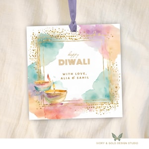 Może przedstawiać: Kwadratowa kartka z życzeniami na Diwali z akwarelami w kolorze turkusowym, różowym i brzoskwiniowym. Złote akcenty obramowują tekst "Happy Diwali" i dwie zapalone lampy naftowe. U góry przymocowana jest fioletowa wstążka.