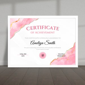 May include: A pink and gold certificate of achievement with a marble design. The certificate is awarded to Ameliya Smith for her outstanding achievements and invaluable contributions to the team's triumph. The date is 13 May, 2024. The certificate is presented by Olivia Wilson.