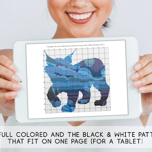 May include: A tablet screen displaying a blue and white cross-stitch pattern of a bear. The text on the screen reads "The pattern fits on one sheet and you can print it... without having to print it..."