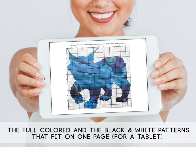 May include: A tablet screen displaying a blue and white cross-stitch pattern of a bear. The text on the screen reads "The pattern fits on one sheet and you can print it... without having to print it..."