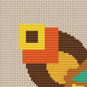 May include: Cross-stitch pattern featuring a geometric design with brown, yellow, orange, and teal squares. The pattern is stitched on a beige fabric.