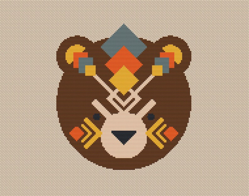 Peut inclure: Un visage d'ours brun avec des motifs g&eacute;om&eacute;triques dans des tons de jaune, orange, bleu et rouge. Le visage de l'ours est stylis&eacute; avec un nez et des yeux simples.