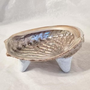 Op de afbeelding: Een set van drie keramische nestkommen in blauwe, groene en witte tinten. De kommen hebben een gespikkelde glazuur en een eenvoudig, modern ontwerp. De grootste kom heeft een diameter van ongeveer 15 cm.