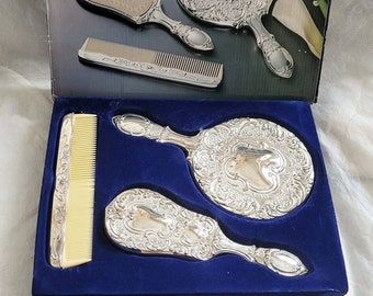 Vintage 3 piece silver plated boxed vanity set, embellished with an attractive floral design, mirror, comb and brush