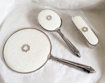 Vintage 3 piece silver metal vanity set, embellished with an attractive floral marcasite centre piece, handled brush, clothes brush & mirror