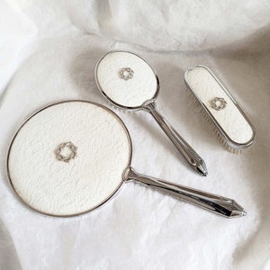 Vintage 3 piece silver metal vanity set, embellished with an attractive floral marcasite centre piece, handled brush, clothes brush & mirror