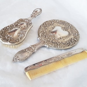 Vintage 3 piece silver plated vanity set, embellished with an attractive floral design, mirror, comb and brush