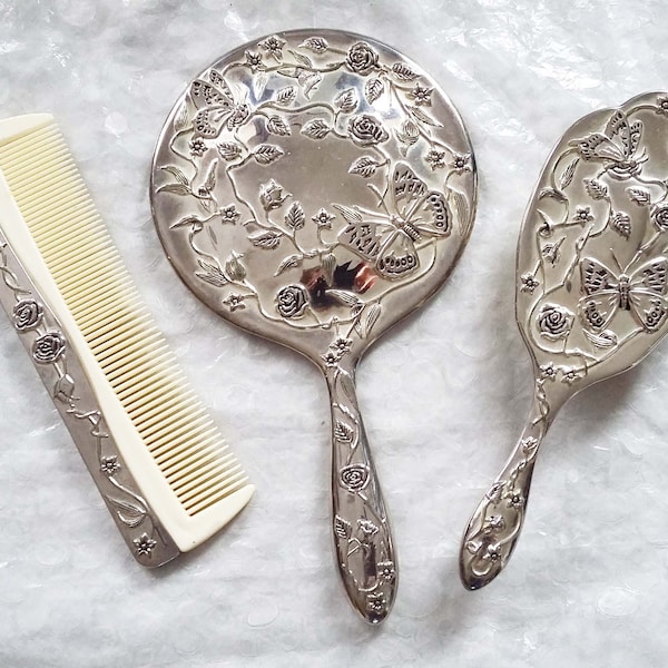 Ensemble de vanité vintage 3 pièces en métal argenté, agrémenté d'un joli motif floral papillon, d'un miroir, d'un peigne et d'une brosse