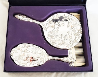 Boxed vintage 3 piece silver plated vanity set, embellished with an attractive floral butterfly design, mirror, comb and brush