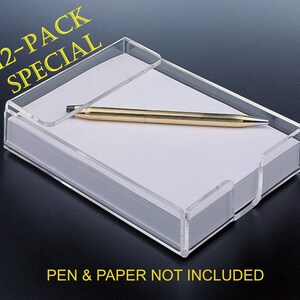 May include: A clear acrylic paper holder containing a stack of white paper with a gold-colored pen resting on top. The text 12-PACK SPECIAL appears in yellow at the top left, and the text PEN & PAPER NOT INCLUDED appears in yellow at the bottom.