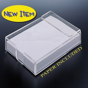 May include: A clear acrylic rectangular memo holder containing a stack of white paper. The holder features a cutout on the front side for easy access. The image includes the yellow oval text NEW ITEM and the yellow text PAPER INCLUDED.