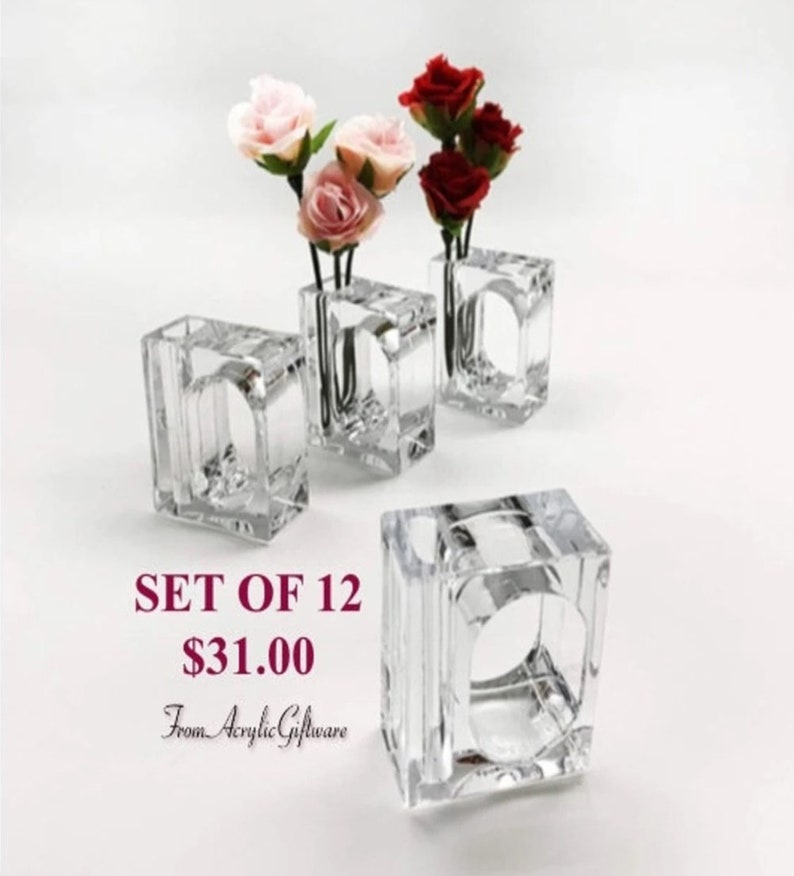 Pode incluir: Conjunto de 12 argolas de guardanapo de acr&iacute;lico transparente. Cada anel tem um pequeno vaso no centro para uma &uacute;nica flor ou ramo. O texto "SET OF 12 $31.00 From Acrylic Giftware" &eacute; vis&iacute;vel na imagem.