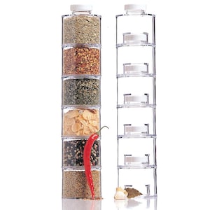 May include: A clear plastic spice rack with six individual containers stacked on top of each other. The containers are filled with various spices, including dried herbs, red pepper flakes, and garlic flakes. A red chili pepper is leaning against the rack.