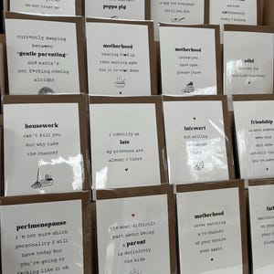 Może przedstawiać: Zbi&oacute;r brązowych kartek z humorystycznymi tekstami i ilustracjami. Kartki zawierają takie zwroty jak "proces", "macierzyństwo", "perimenopauza", "prace domowe", "przyjaźń", "introwertyk", "ADHD", "p&oacute;źno", "delikatne rodzicielstwo", "Peppa Pig" oraz "najtrudniejszą częścią bycia rodzicem są zdecydowanie dzieci".