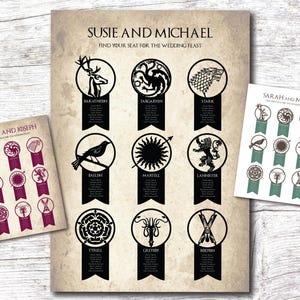 May include: Wedding seating chart featuring various house sigils from a fantasy series. The chart includes names like Baratheon, Targaryen, and Stark, with guest names listed below each sigil. Additional smaller charts are also visible.