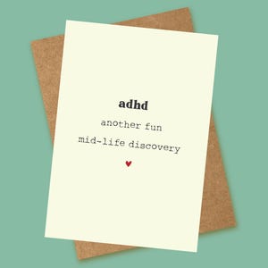 May include: A white card with black text that reads "adhd another fun mid-life discovery" with a small red heart at the bottom.