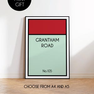 Pu&ograve; includere: Un poster minimalista con cornice nera, che presenta uno schema di colori rosso e verde. Il poster recita "Grantham Road" con il numero "No. 105" in basso. Il poster &egrave; disponibile nei formati A4 e A5.