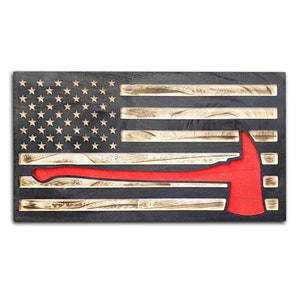 May include: A wooden American flag with a red fire axe cut out of the center. The flag is distressed and has a rustic look.