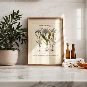 Kitchen counter showing a framed printable featuring Proverbs 3:5-6 Bible Verse paired with illustrated vintage botanicals.