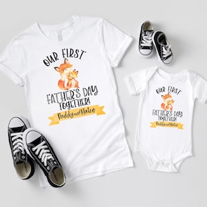 May include: White t-shirts and a baby onesie with a fox graphic and the text "OUR FIRST FATHER'S DAY TOGETHER! Daddy and Mateo." Black canvas sneakers are also in the image.