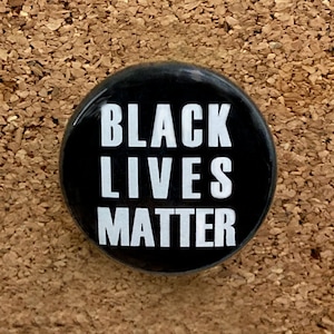 May include: Black button with white text that reads "Black Lives Matter".