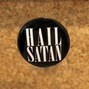 May include: A black button with white text that reads "HAIL SATAN".