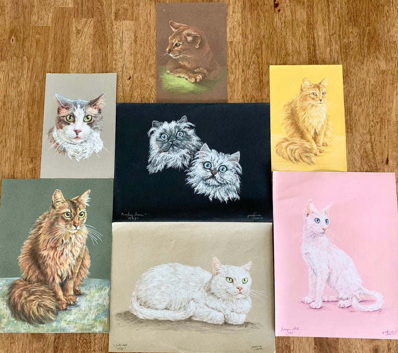 May include: A collection of nine vintage cat illustrations printed on paper. The illustrations feature cats of different breeds and colours in various poses. Some of the cats are sitting, while others are lying down or standing. The illustrations are all in a realistic style and are framed in white.