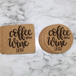 May include: Two cork coasters with the text "coffee now wine later" in black script. One coaster is square and the other is round.
