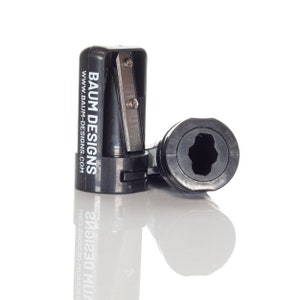 May include: Black pencil sharpener with a silver blade and a white label that reads "BAUM DESIGNS WWW.BAUM-DESIGNS.COM".
