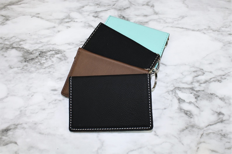 May include: Three leather keychains in black, brown, and light blue. Each keychain has a silver ring.