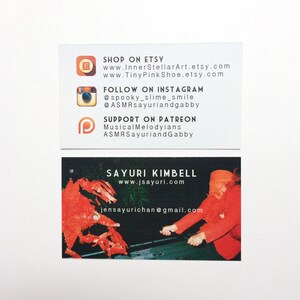May include: Two business cards on a white background. The top card lists Etsy, Instagram, and Patreon details. The bottom card displays the name Sayuri Kimbell, a website, and an email address. The bottom card has a red and black graphic.