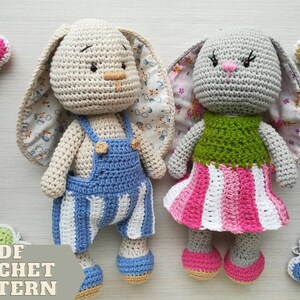 May include: Two crocheted bunny dolls, one in blue striped dungarees and the other in a pink and white striped dress. The bunnies have long ears with patterned fabric inside. Crochet hearts surround the dolls.