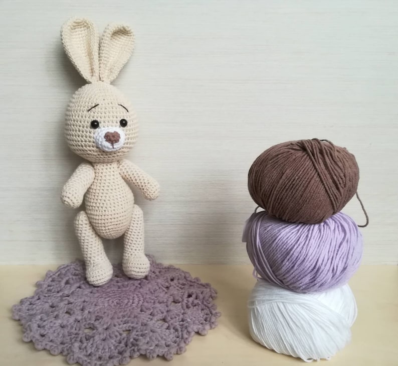 crochet lovely Bunny with heart as toy for child. Stuffed Rabbit with decorative egg as Easter gift