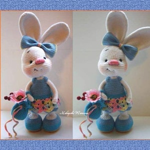 May include: A white crocheted rabbit wearing a blue dress and a blue bow. The rabbit is holding a pink flower and is standing on a white surface. The image is labelled "RABBIT GOLDY CROCHET PATTERN".