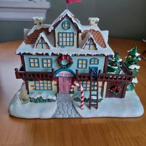 May include: A white ceramic mug with a black handle and the text "But First, Coffee" in a bold, black font. The mug is set against a blurred background, highlighting its simple design.