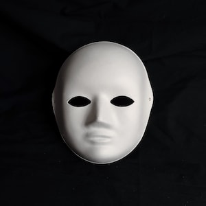 Pu&ograve; includere: Una maschera bianca vuota con fori per gli occhi e una bocca semplice. La maschera &egrave; realizzata in un materiale liscio e opaco e ha una forma leggermente arrotondata.