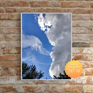 May include: A framed photograph of a bright blue sky with dramatic white and gray clouds. The image includes a glimpse of tree branches at the bottom and a sticker that reads "Original Photography NO AI".