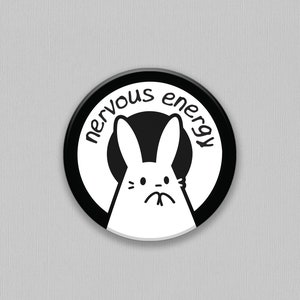 May include: Black and white button featuring a white bunny with a nervous expression and the text "nervous energy" surrounding the bunny.